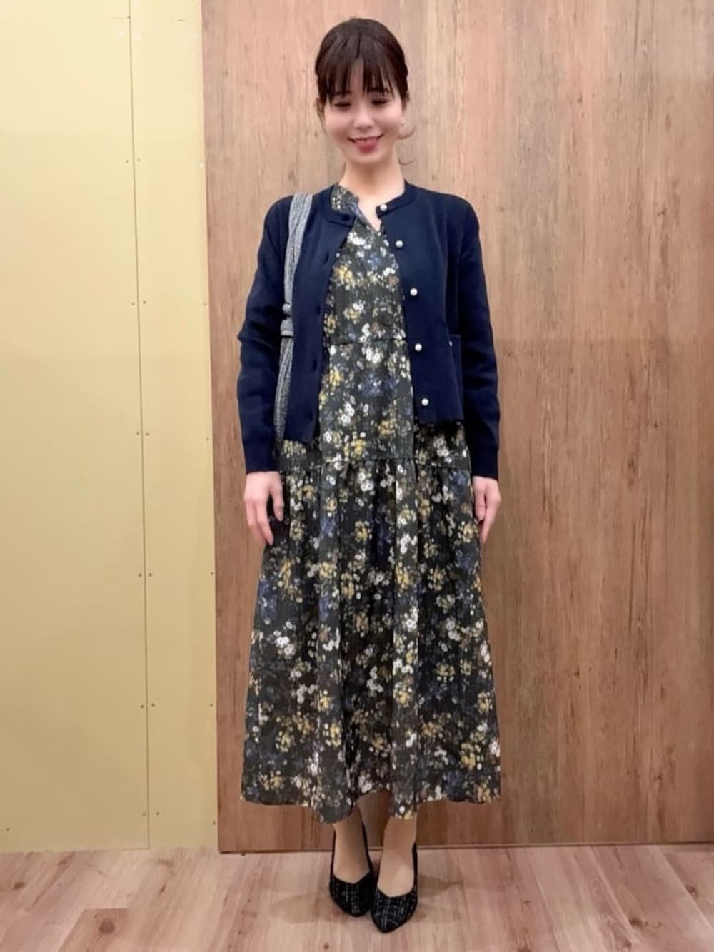 ブラック系のパンプス、シルバー系のショルダーバッグ、グリーン系のワンピースを着用したレディースの冬コーディネートの1枚目の写真
