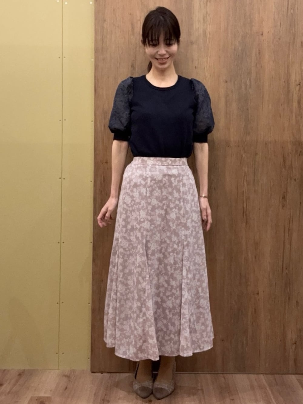 ブラウン系のパンプス、ピンク系のスカート、ブルー系のニット/セーターを着用したレディースの春コーディネートの1枚目の写真