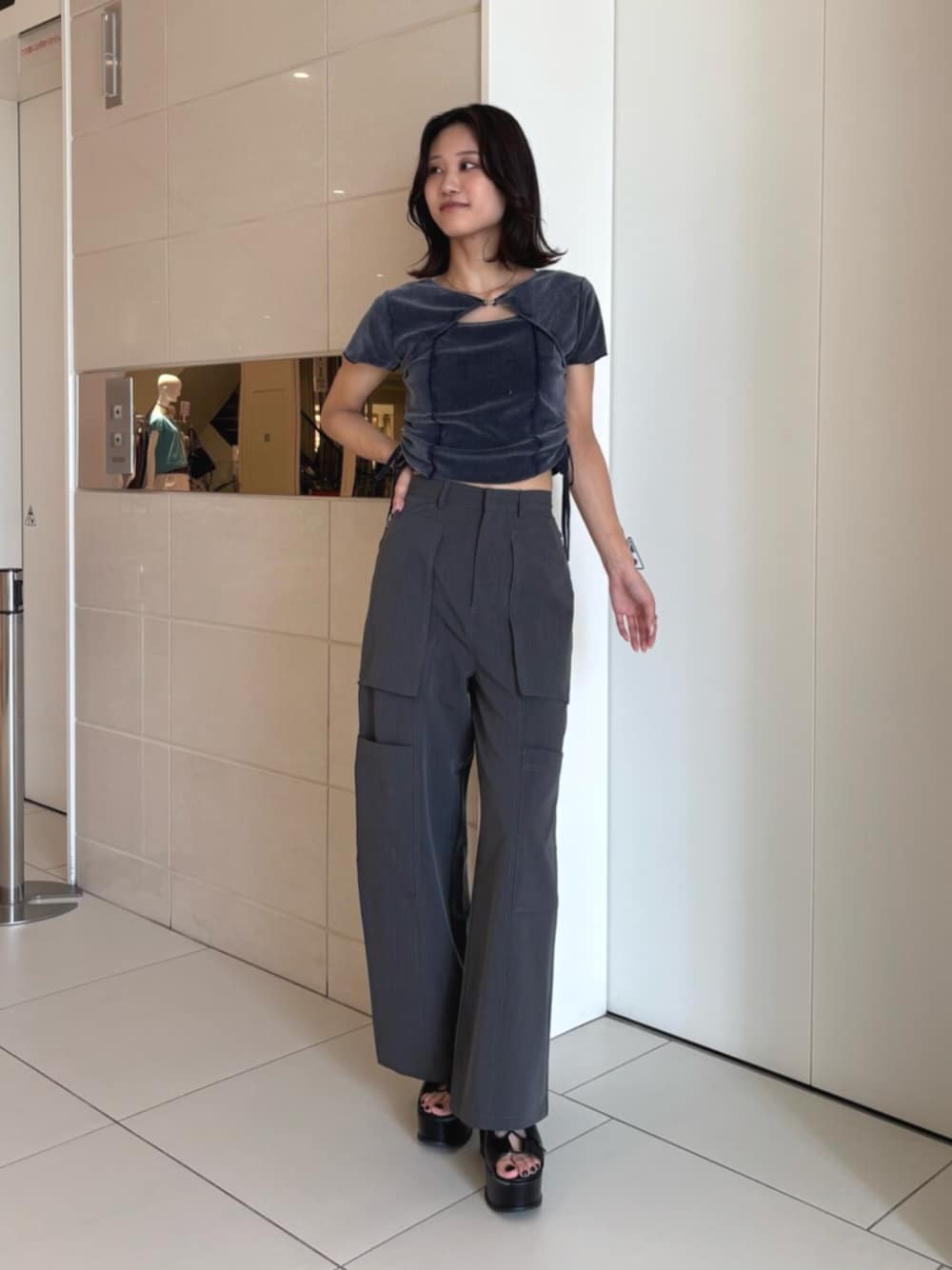 ブラック系のサンダル、グレー系のスラックス、ブルー系のTシャツ/カットソーを着用したレディースの夏コーディネートの1枚目の写真