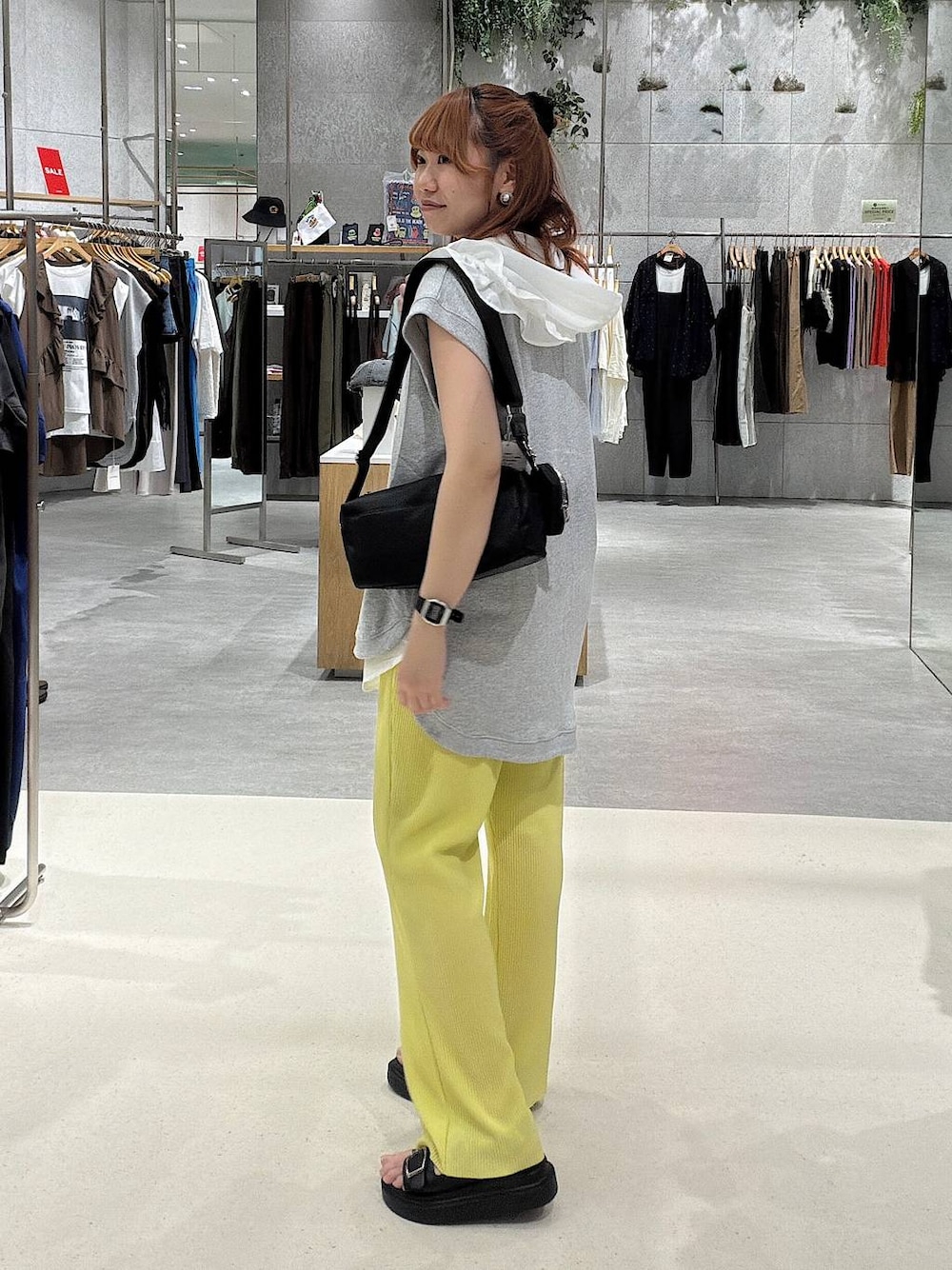 ブラック系のショルダーバッグ、グレー系のベスト、イエロー系のその他パンツを着用したレディースの夏コーディネートの1枚目の写真