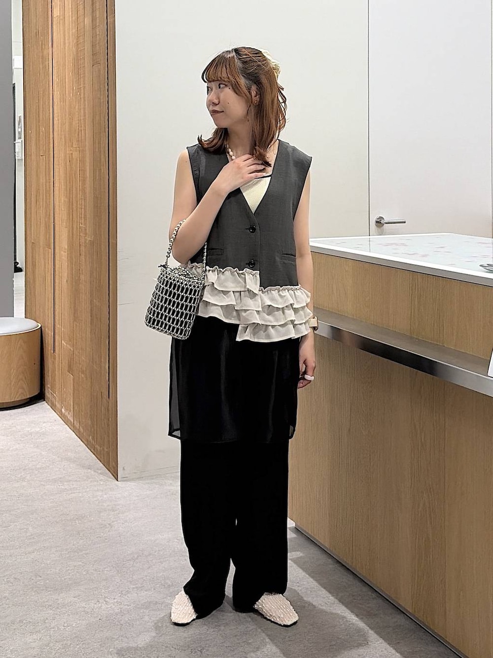 シルバー系のショルダーバッグ、ホワイト系のタンクトップ、ホワイト系のパンプスを着用したレディースの春コーディネートの1枚目の写真