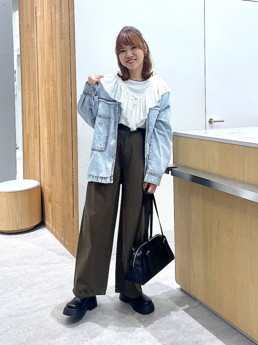 ブラック系のボストンバッグ、ブラック系のその他シューズ、グリーン系のその他パンツを着用したレディースの冬コーディネートの1枚目の写真