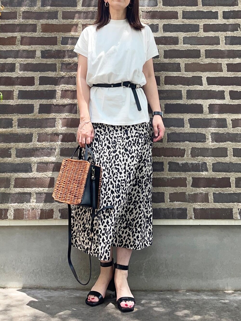 ホワイト系のTシャツ/カットソー、ベージュ系のスカート、ブラック系のサンダルを着用したレディースの夏コーディネートの1枚目の写真