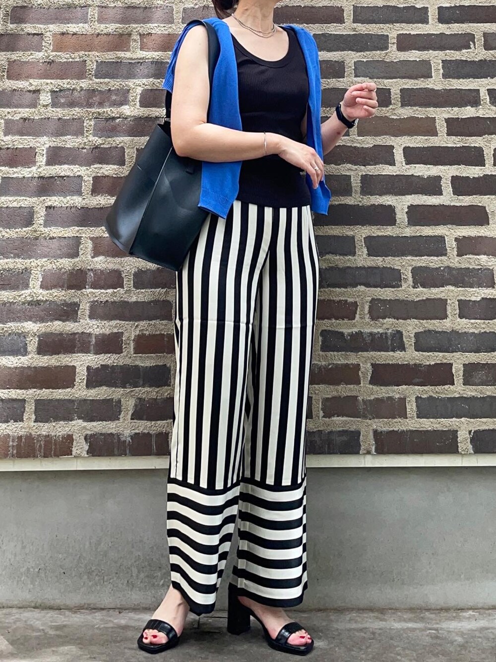 ブラック系のその他パンツ、ブルー系のカーディガン/ボレロ、ホワイト系のタンクトップを着用したレディースの夏コーディネートの1枚目の写真