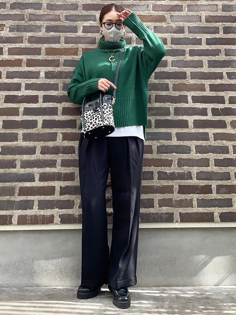 グリーン系のニット/セーター、ブラック系のその他パンツ、ブラック系のローファーを着用したレディースの秋コーディネートの1枚目の写真