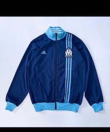 adidas | フランスのプロサッカークラブ、オリンピック・マルセイユのアディダス製トラックジャケット。左胸にはクラブのエンブレムと「DROIT AU BUT」(ゴールへ一直線)の文字。 (ジャージ)