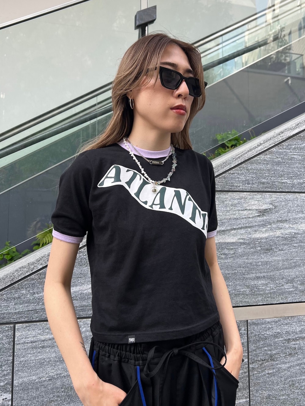 ブラック系のスラックス、ブラック系のTシャツ/カットソー、ブラック系のサンダルを着用したレディースの夏コーディネートの3枚目の写真