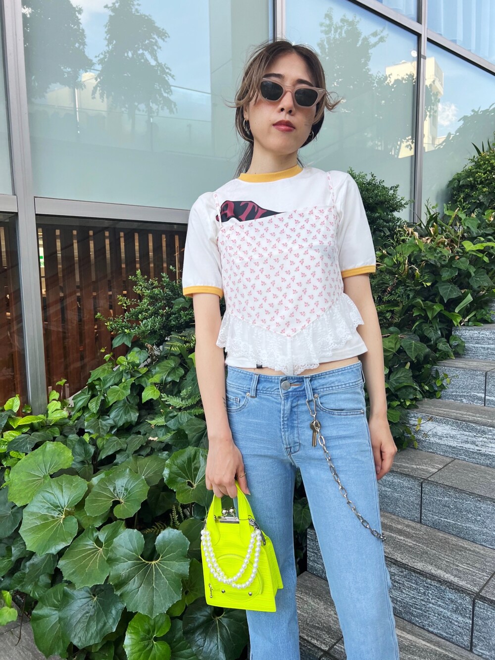 イエロー系のショルダーバッグ、ホワイト系のキャミソール、ホワイト系のTシャツ/カットソーを着用したレディースの夏コーディネートの2枚目の写真