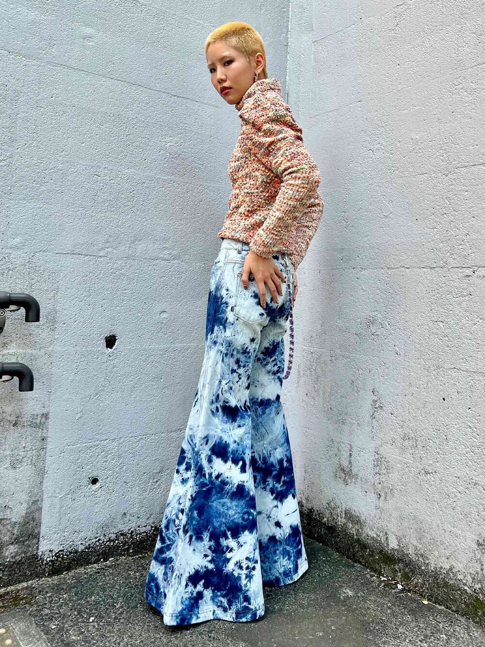 ベージュ系のニット/セーター、ブルー系のデニムパンツ、パープル系のウォレットチェーンを着用したレディースの秋コーディネートの2枚目の写真