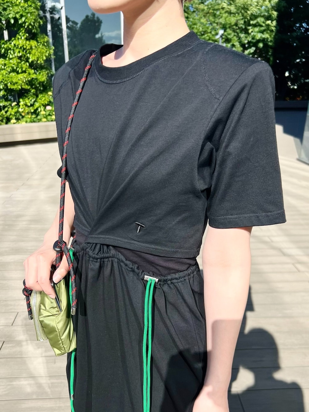 ブラック系のワンピース、グリーン系のショルダーバッグを着用したレディースの夏コーディネートの2枚目の写真