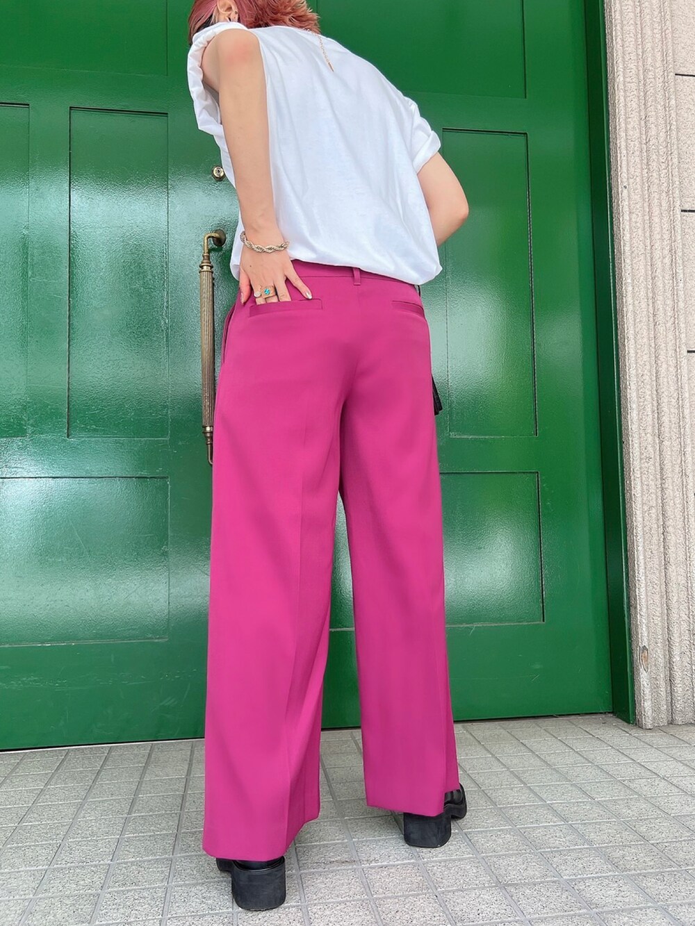 ホワイト系のTシャツ/カットソー、ブラック系のショルダーバッグ、ピンク系のスラックスを着用したレディースの夏コーディネートの3枚目の写真
