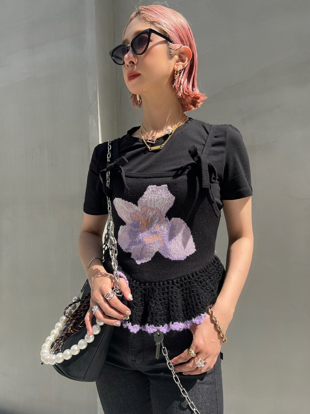 ブラック系のデニムパンツ、ブラック系のニット/セーター、ブラック系のトートバッグを着用したレディースの夏コーディネートの2枚目の写真