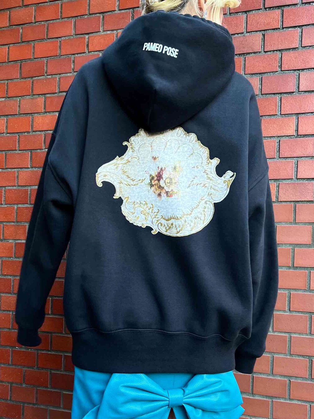 ブラック系のパーカー、ブルー系のスカート、シルバー系のピアス（両耳用）を着用したレディースの冬コーディネートの2枚目の写真