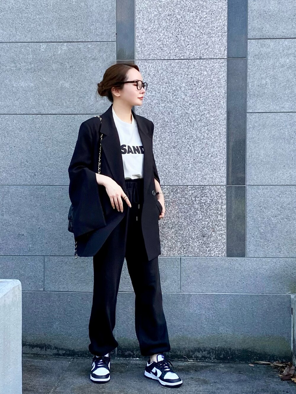 ホワイト系のTシャツ/カットソー、ホワイト系のスニーカー、ブラック系のメガネを着用したレディースの秋コーディネートの2枚目の写真