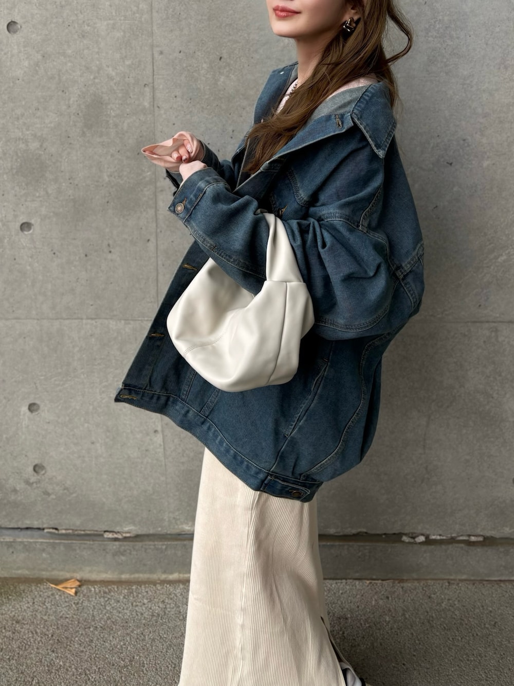 ブルー系のデニムジャケット、ホワイト系のスニーカーを着用したレディースの冬コーディネートの3枚目の写真