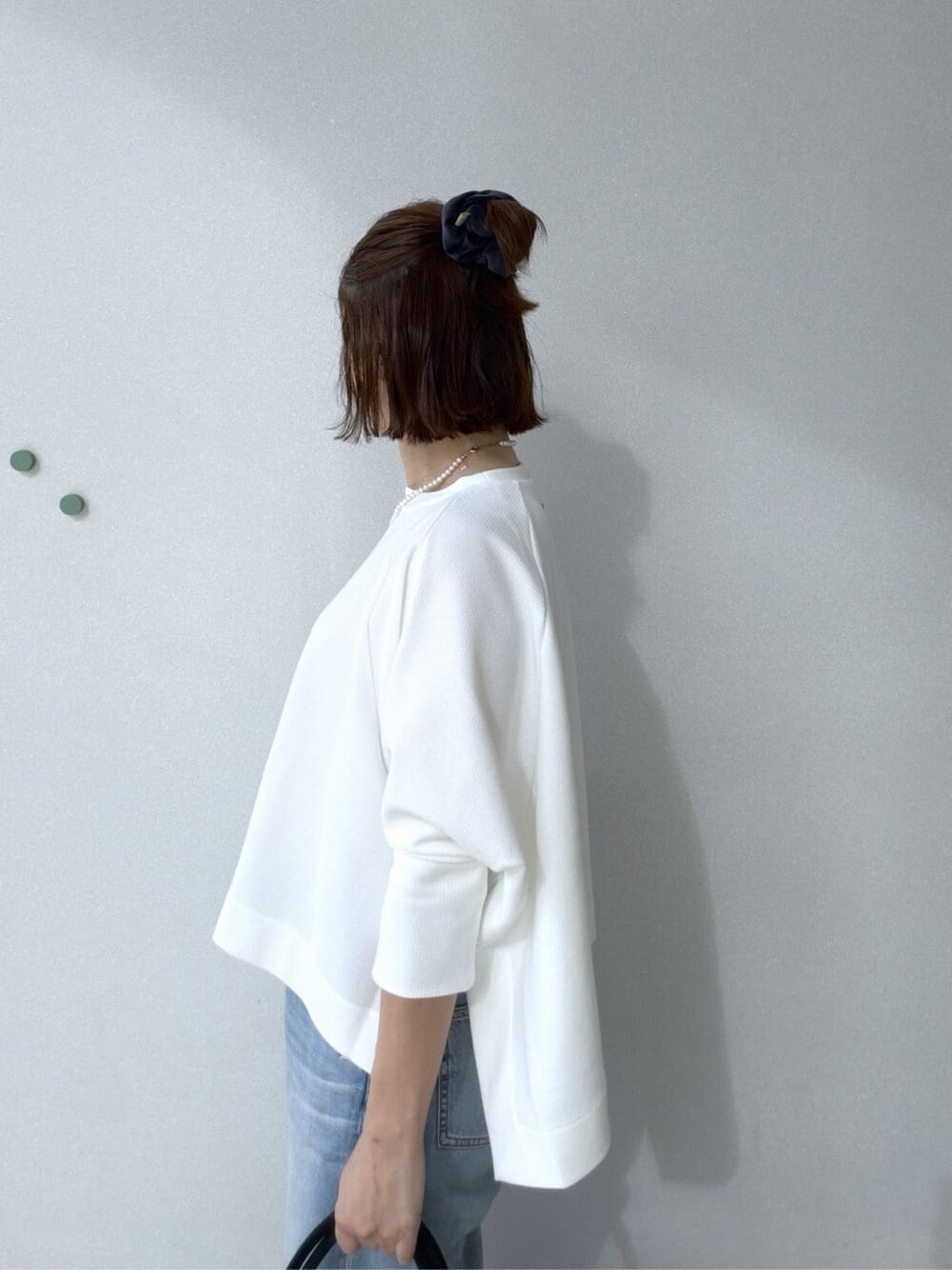 ホワイト系のTシャツ/カットソー、ブルー系のデニムパンツ、ブラック系のトートバッグを着用したレディースの冬コーディネートの8枚目の写真