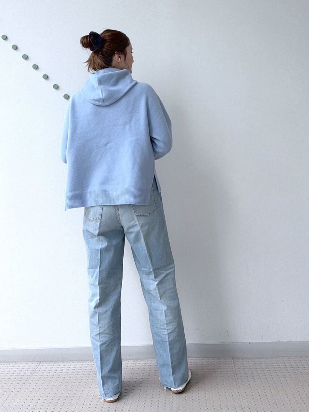 ブルー系のニット/セーター、ブルー系のデニムパンツ、ブラック系のボストンバッグを着用したレディースの冬コーディネートの3枚目の写真