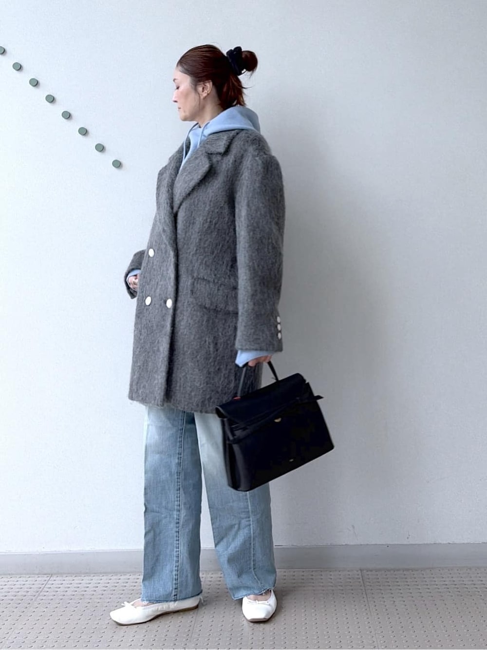 ブルー系のニット/セーター、ブルー系のデニムパンツ、ブラック系のボストンバッグを着用したレディースの冬コーディネートの7枚目の写真