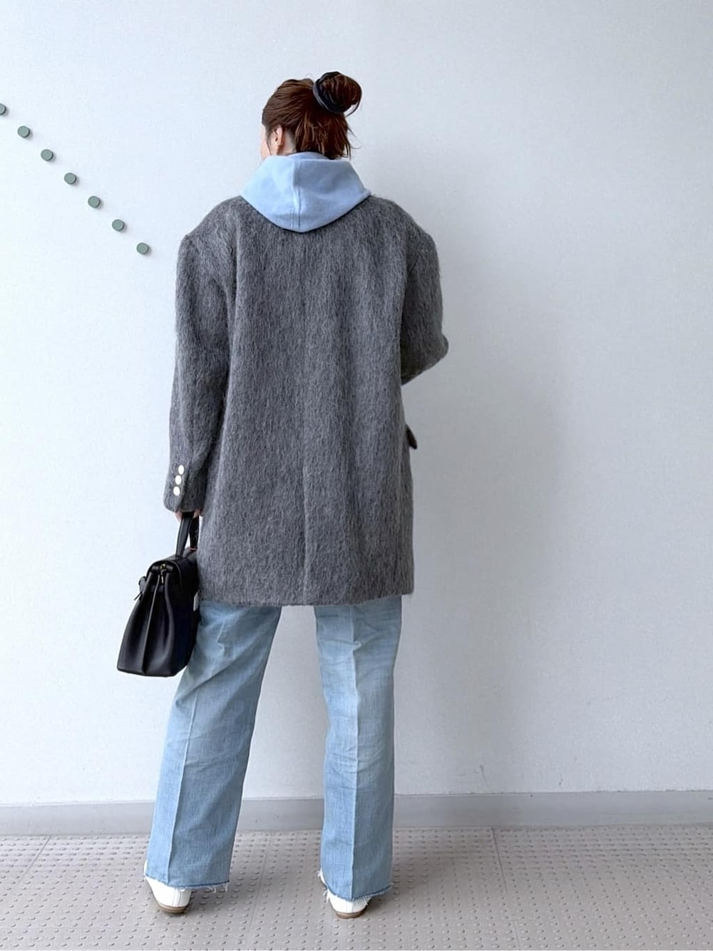 ブルー系のニット/セーター、ブルー系のデニムパンツ、ブラック系のボストンバッグを着用したレディースの冬コーディネートの8枚目の写真
