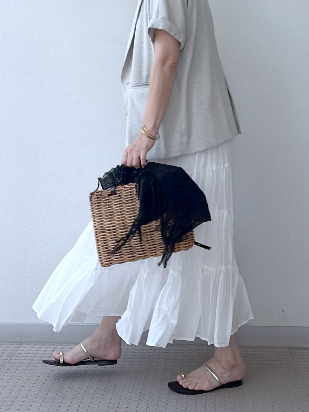 ホワイト系のスカート、ブラウン系のTシャツ/カットソー、ベージュ系のテーラードジャケットを着用したレディースの夏コーディネートの6枚目の写真