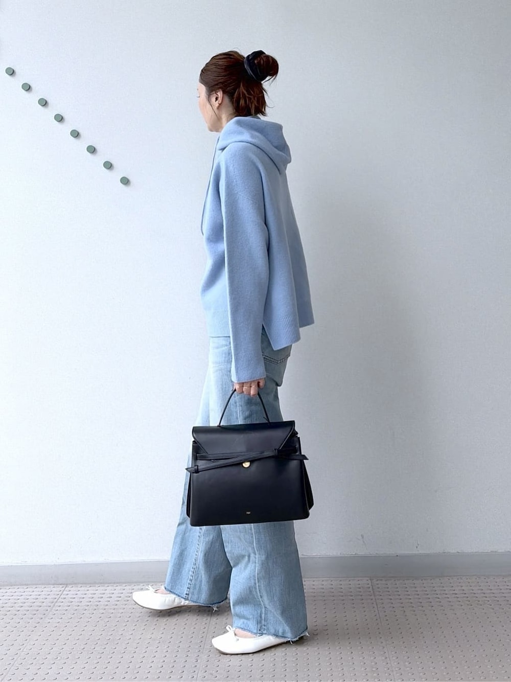 ブルー系のニット/セーター、ブルー系のデニムパンツ、ブラック系のボストンバッグを着用したレディースの冬コーディネートの4枚目の写真