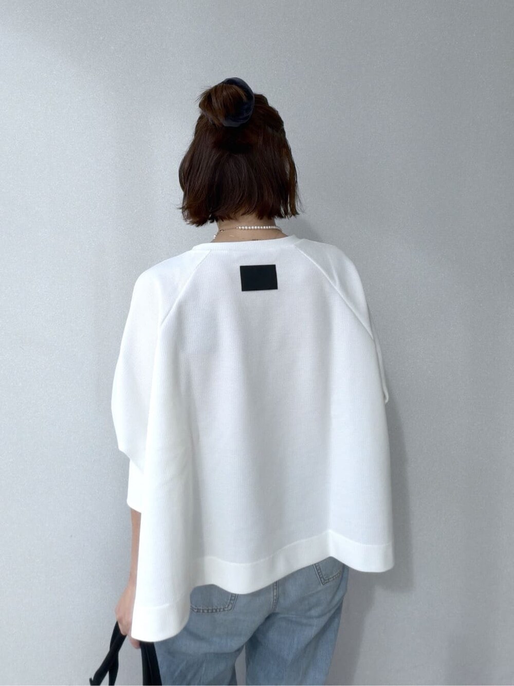 ホワイト系のTシャツ/カットソー、ブルー系のデニムパンツ、ブラック系のトートバッグを着用したレディースの冬コーディネートの7枚目の写真