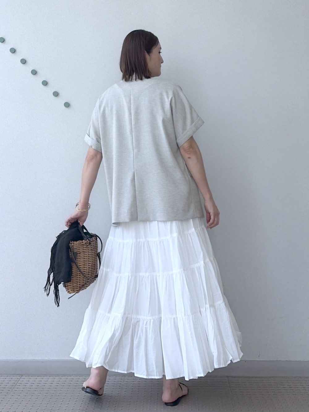 ホワイト系のスカート、ブラウン系のTシャツ/カットソー、ベージュ系のテーラードジャケットを着用したレディースの夏コーディネートの4枚目の写真