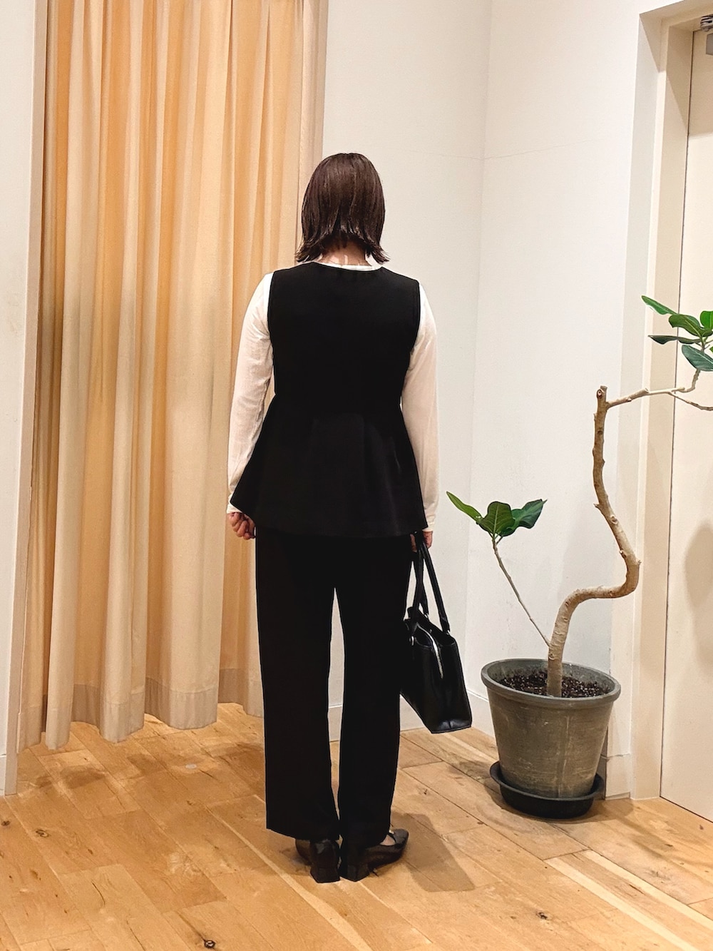 ブラック系のセットアップ、ホワイト系のTシャツ/カットソー、ブラック系のパンプスを着用したレディースの秋コーディネートの4枚目の写真