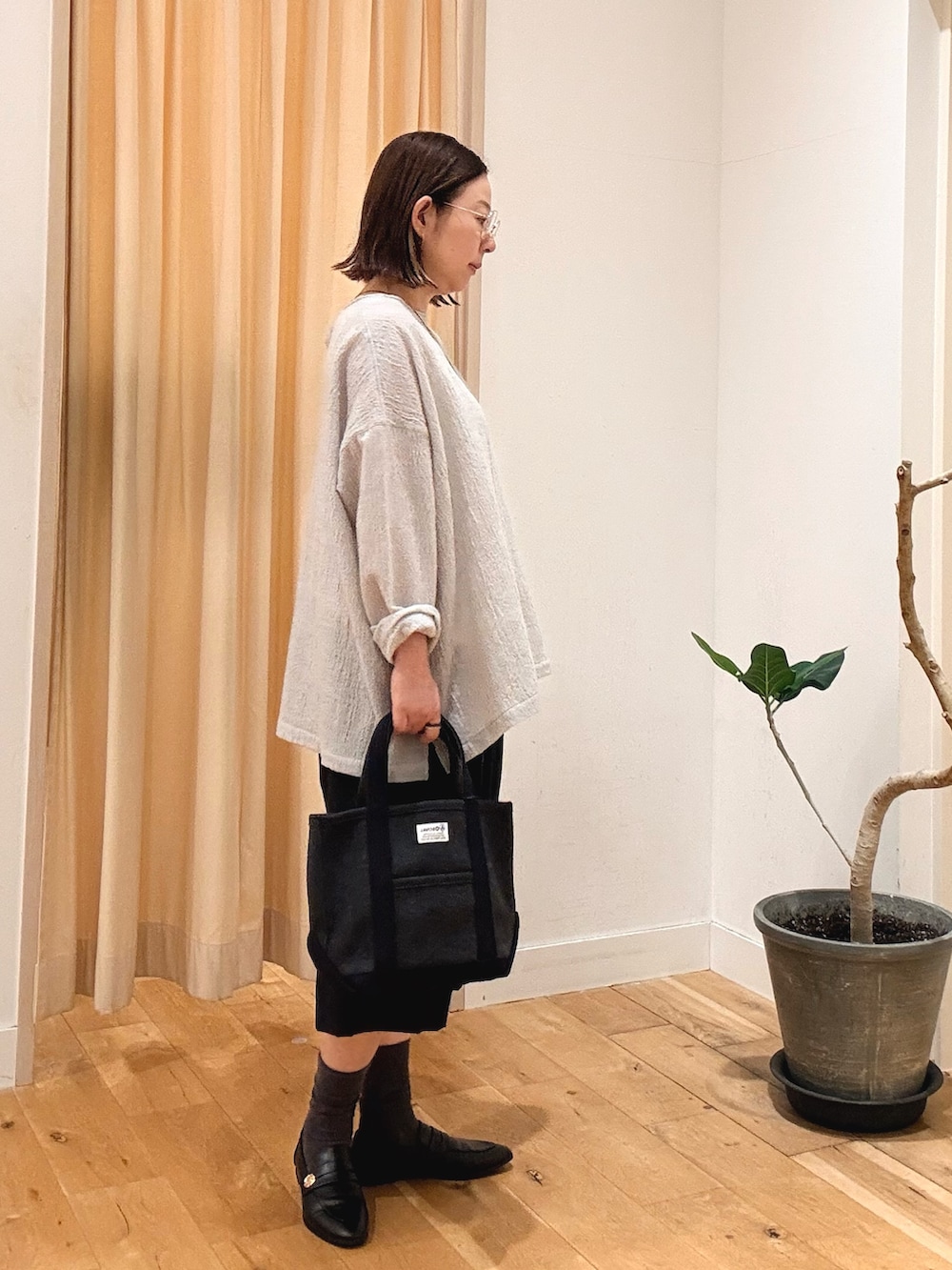 グレー系のシャツ/ブラウス、ブラック系のローファー、グレー系のトートバッグを着用したレディースの秋コーディネートの2枚目の写真
