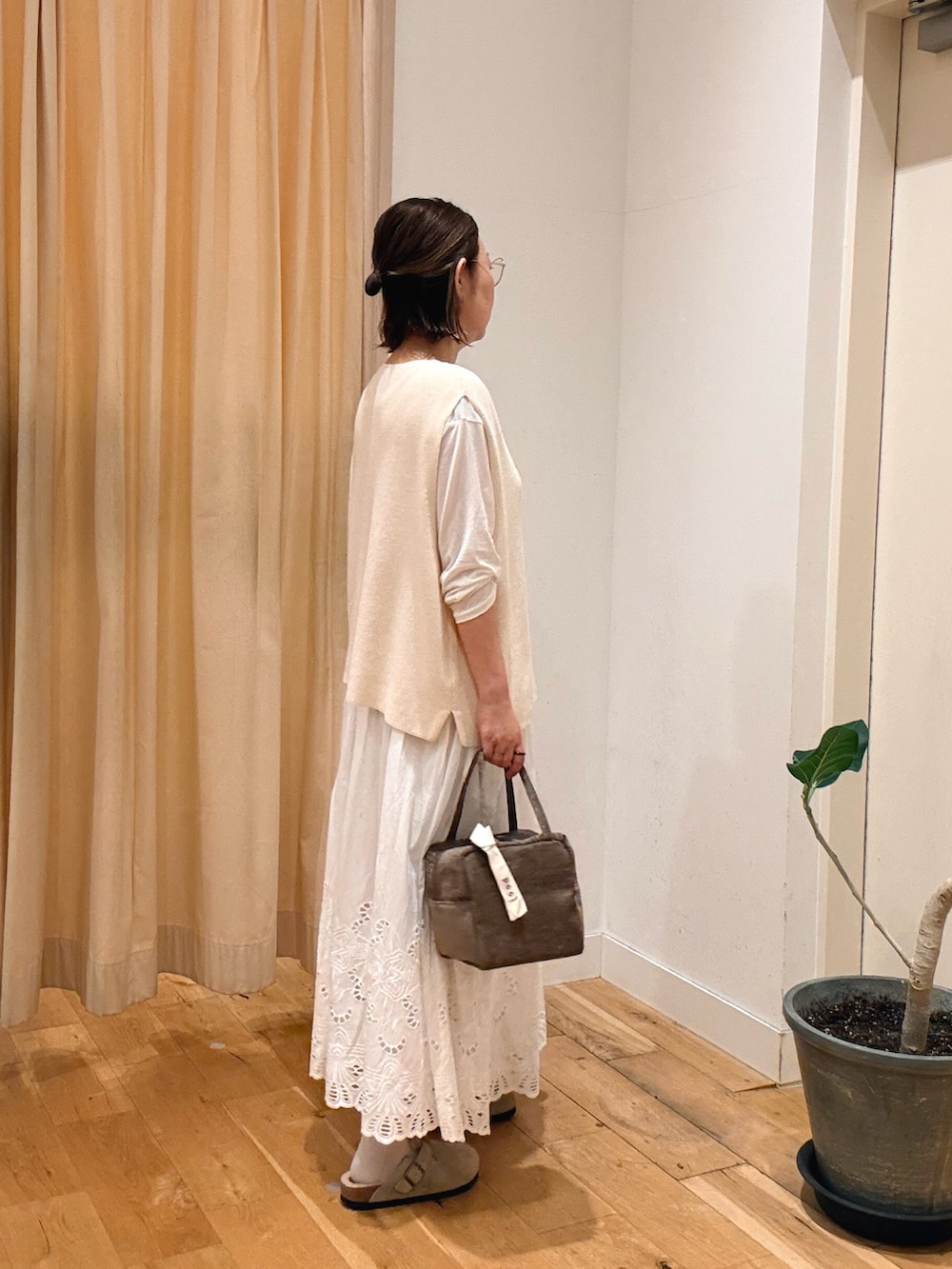 ホワイト系のスカート、ホワイト系のTシャツ/カットソー、ホワイト系のベストを着用したレディースの秋コーディネートの2枚目の写真