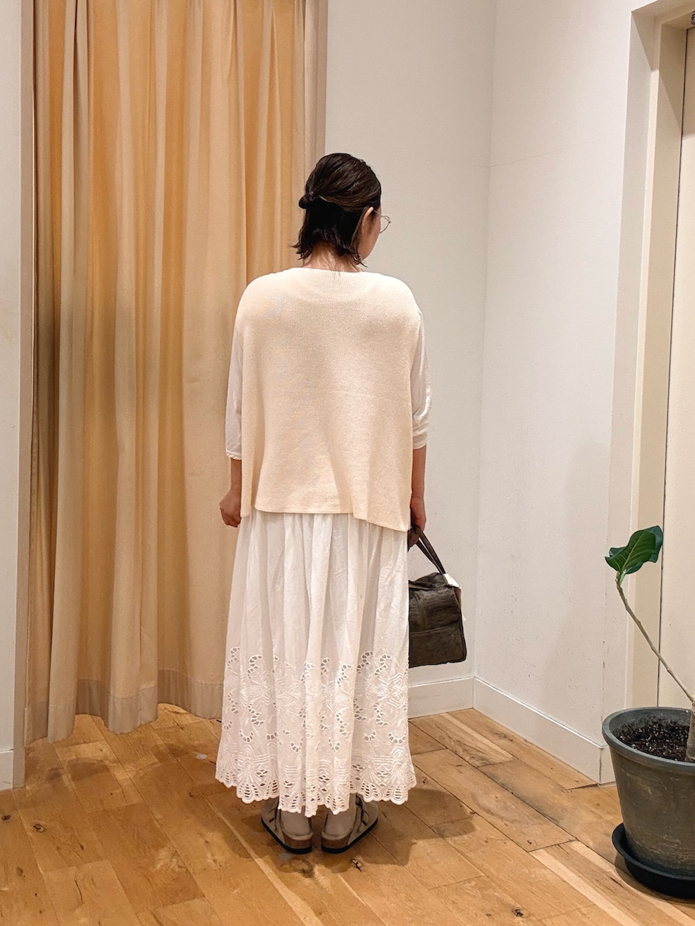 ホワイト系のスカート、ホワイト系のTシャツ/カットソー、ホワイト系のベストを着用したレディースの秋コーディネートの3枚目の写真