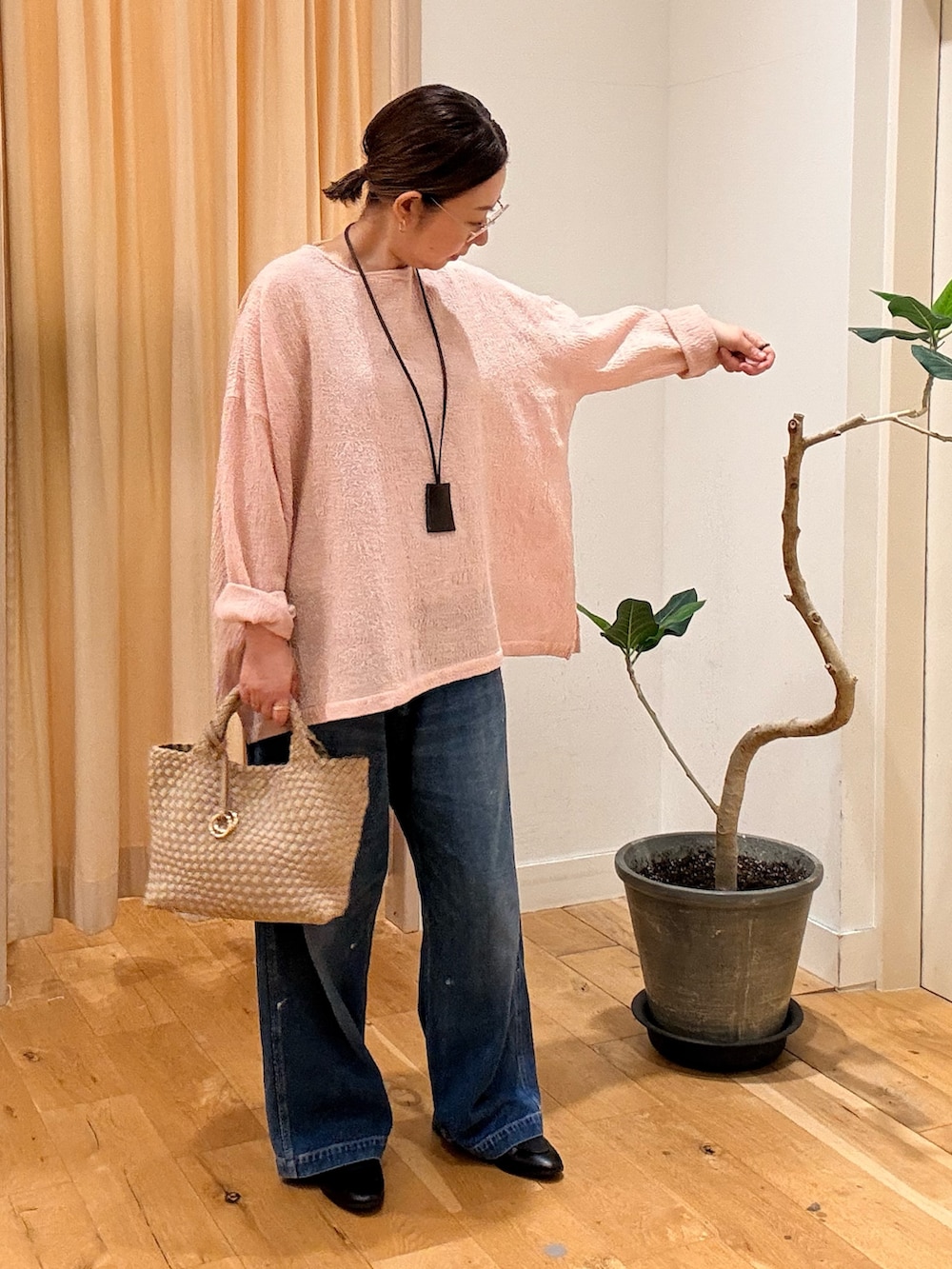 ブラック系のローファー、ブルー系のデニムパンツ、ベージュ系のハンドバッグを着用したレディースの秋コーディネートの3枚目の写真