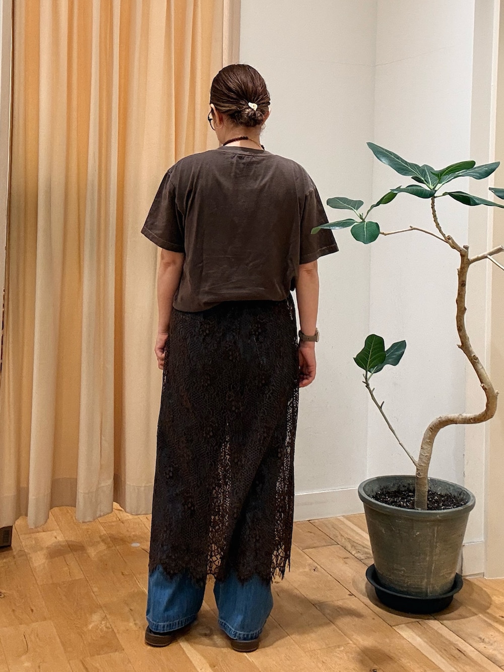 ブラウン系のスカート、ブラウン系のTシャツ/カットソー、ブルー系のデニムパンツを着用したレディースの夏コーディネートの3枚目の写真