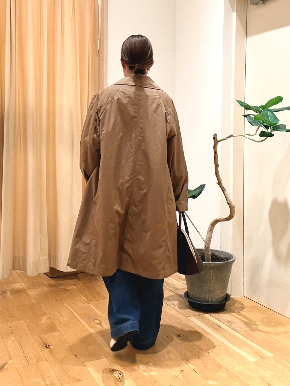レッド系のハンドバッグ、ブルー系のシャツ/ブラウス、ブルー系のデニムパンツを着用したレディースの秋コーディネートの2枚目の写真