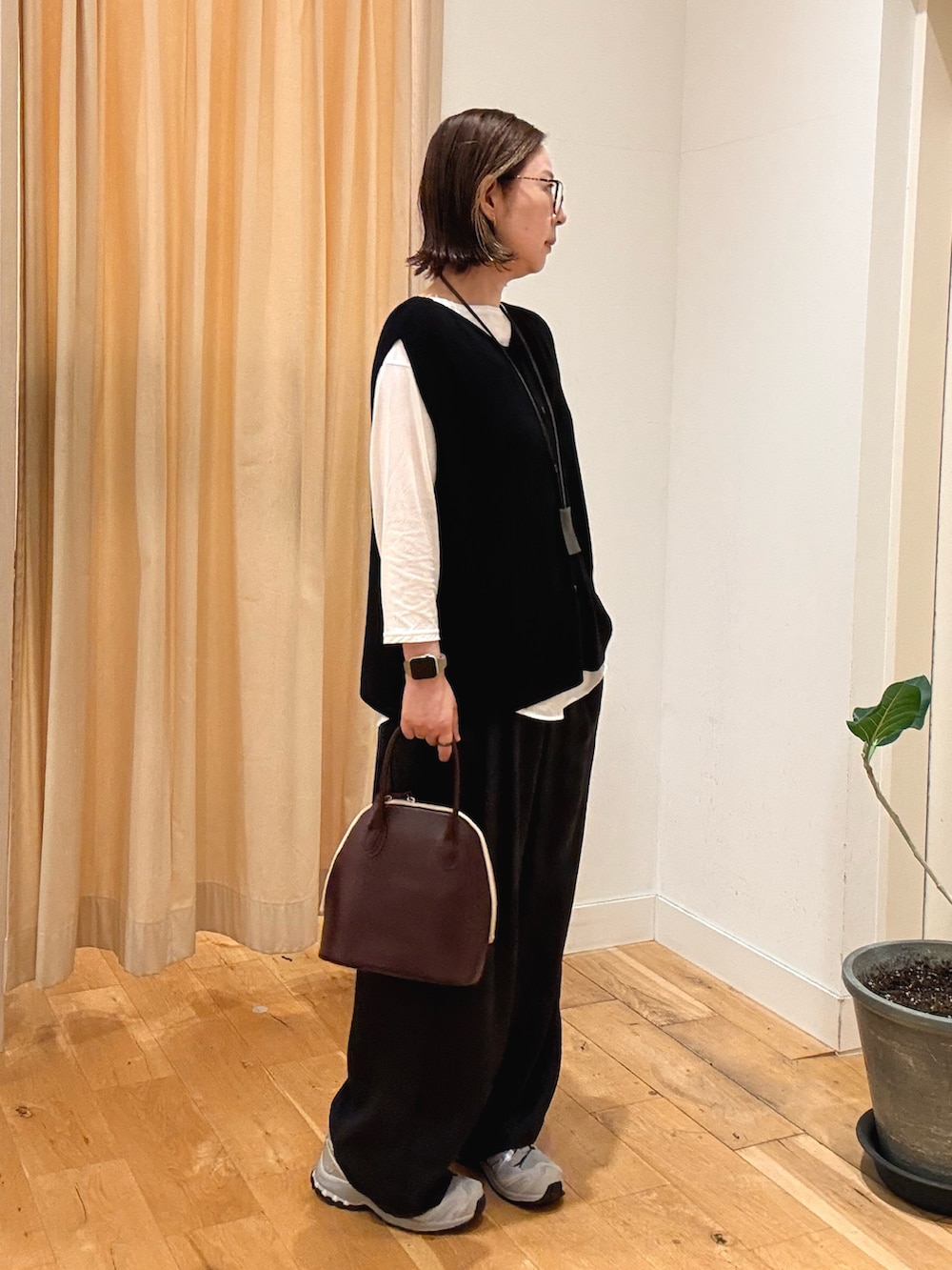 ブラック系のその他パンツ、レッド系のハンドバッグ、グレー系のスニーカーを着用したレディースの秋コーディネートの3枚目の写真