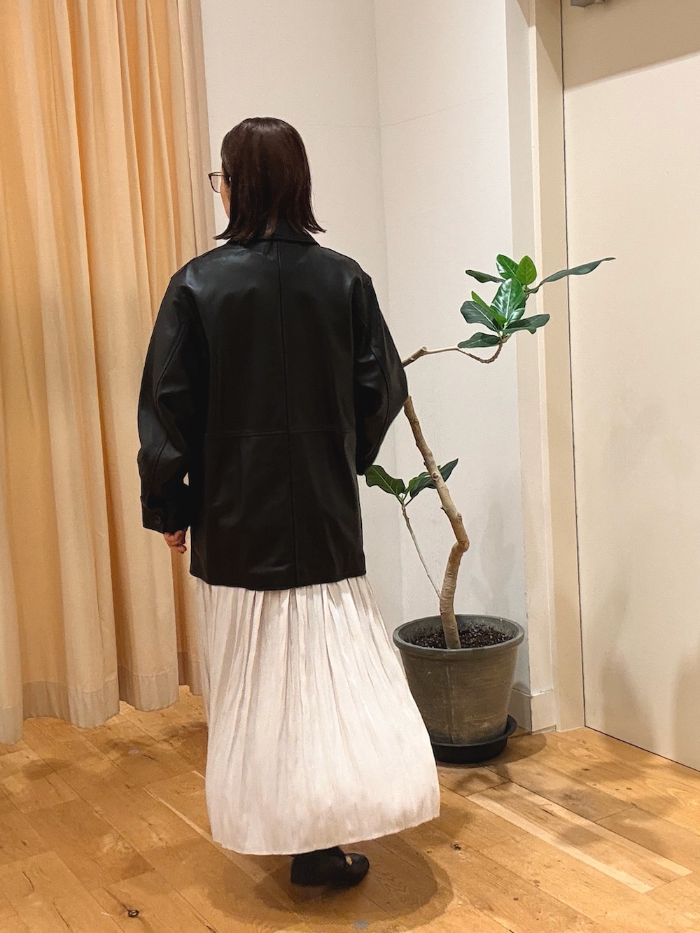 ブラック系のその他アウター、ホワイト系のスカート、ブラック系のローファーを着用したレディースの秋コーディネートの3枚目の写真