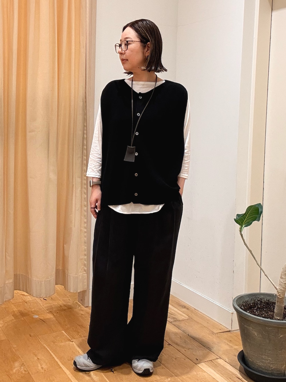 ブラック系のその他パンツ、レッド系のハンドバッグ、グレー系のスニーカーを着用したレディースの秋コーディネートの4枚目の写真
