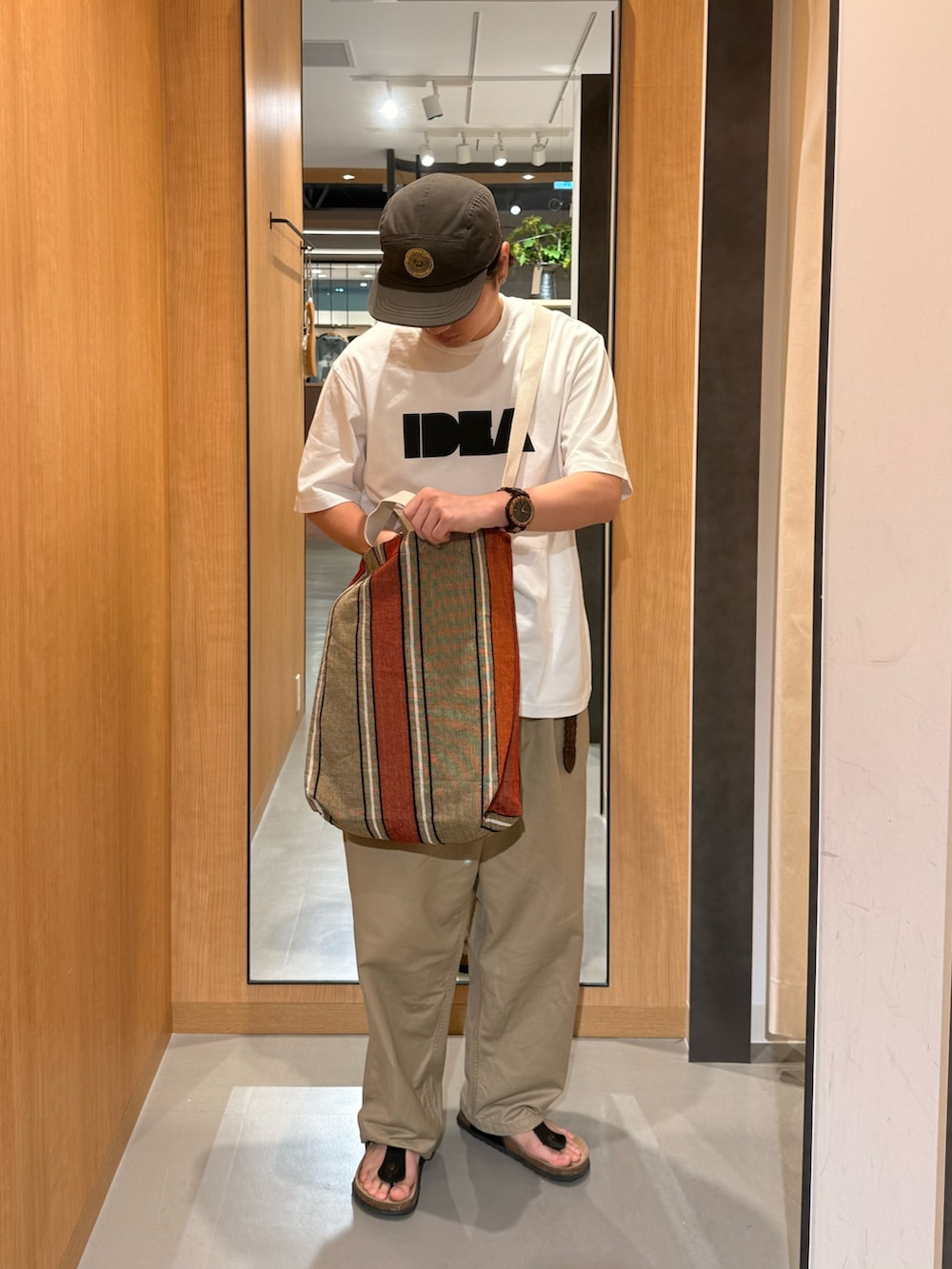 ホワイト系のTシャツ/カットソー、オレンジ系のトートバッグを着用したメンズの夏コーディネートの3枚目の写真