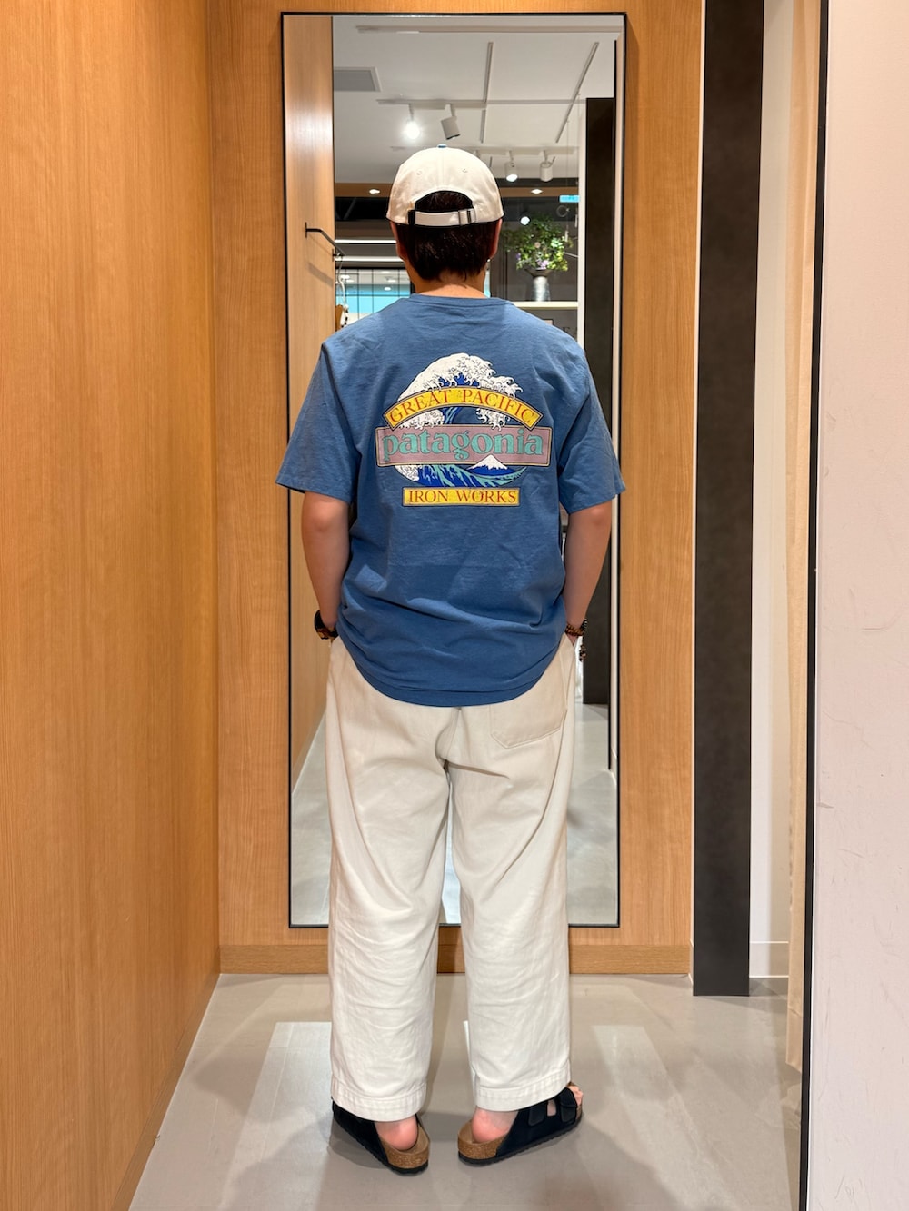 ブルー系のTシャツ/カットソー、ブラック系のサンダル、ホワイト系のキャップを着用したメンズの春コーディネートの3枚目の写真