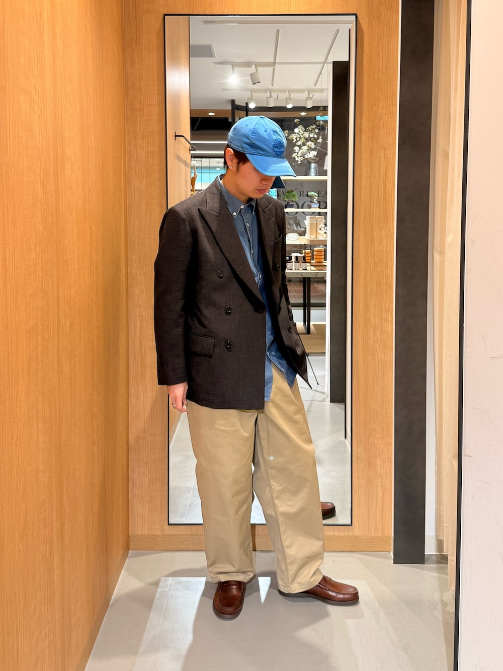 ブラウン系のその他アウター、ベージュ系のその他パンツ、ブルー系のシャツ/ブラウスを着用したメンズの春コーディネートの2枚目の写真