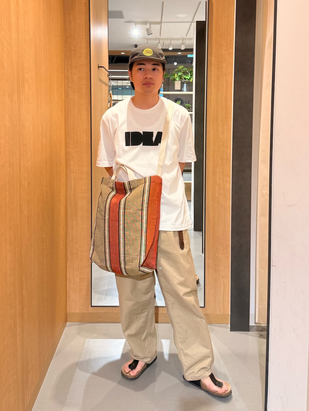 ホワイト系のTシャツ/カットソー、オレンジ系のトートバッグを着用したメンズの夏コーディネートの2枚目の写真