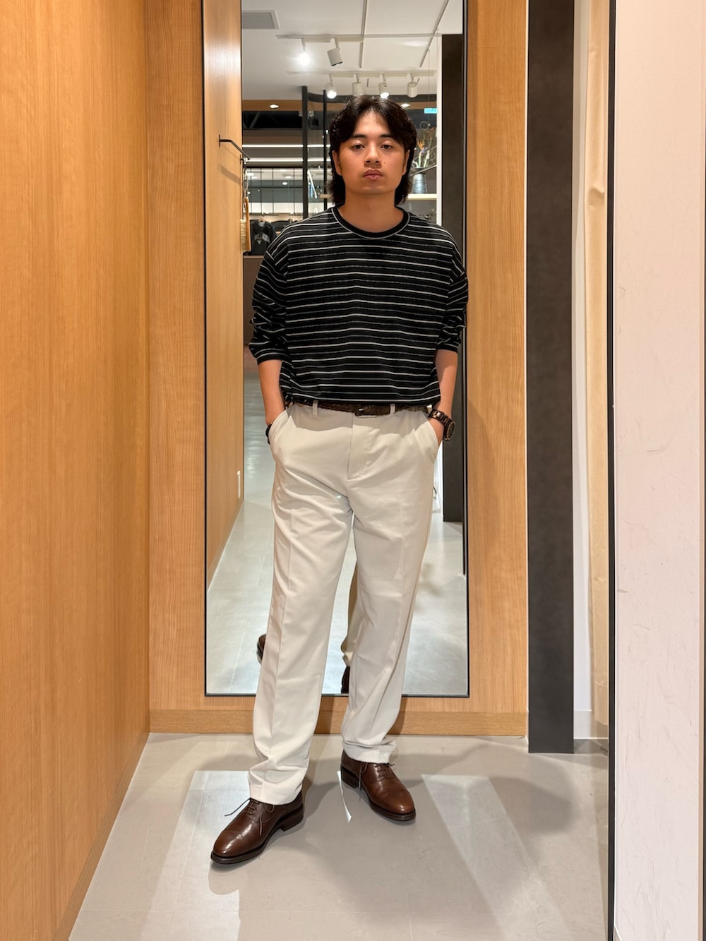 ブラック系のTシャツ/カットソー、ベージュ系のその他パンツ、ブラウン系のドレスシューズを着用したメンズの夏コーディネートの2枚目の写真