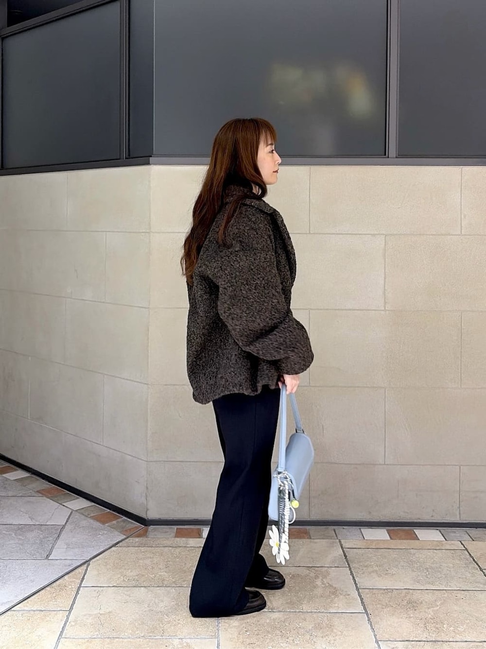 ブラウン系のピーコート、グレー系のニット/セーター、ブラック系のその他パンツを着用したレディースの冬コーディネートの4枚目の写真