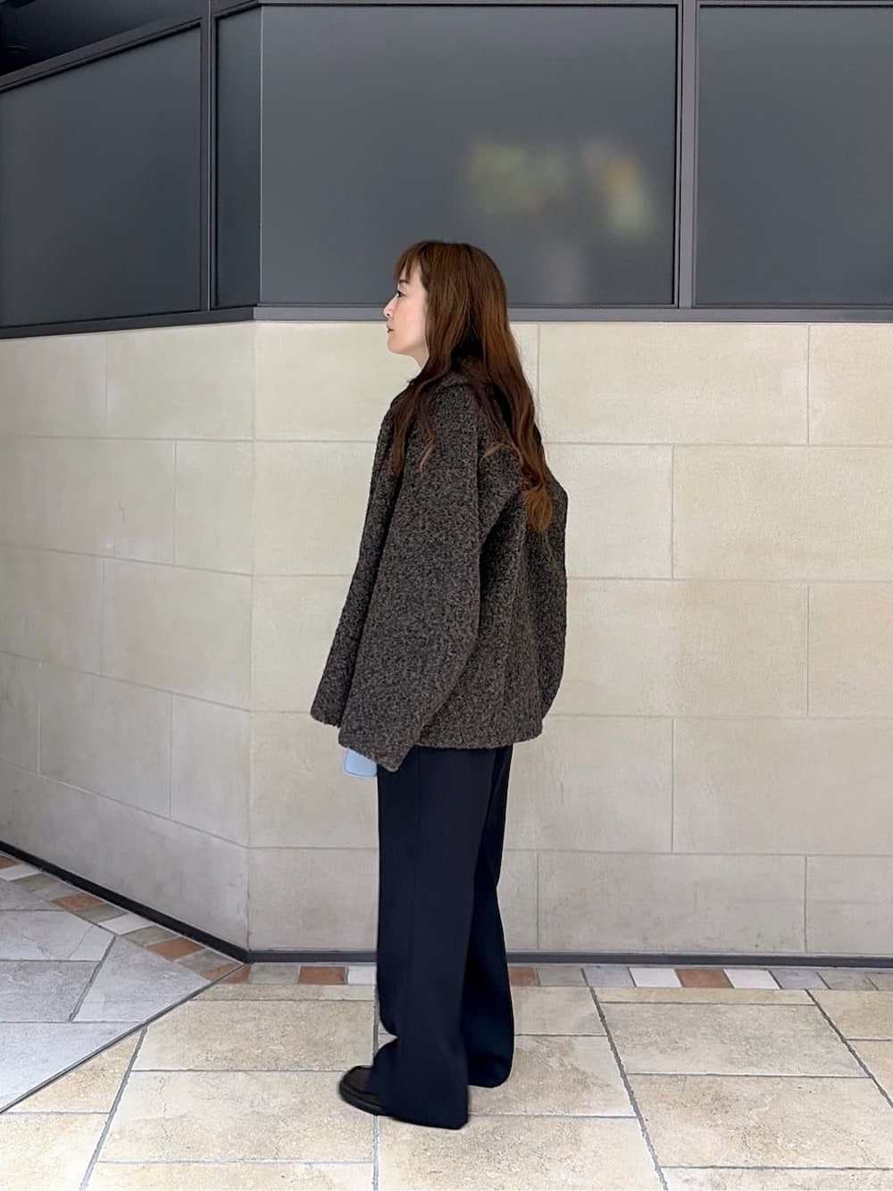 ブラウン系のピーコート、グレー系のニット/セーター、ブラック系のその他パンツを着用したレディースの冬コーディネートの2枚目の写真