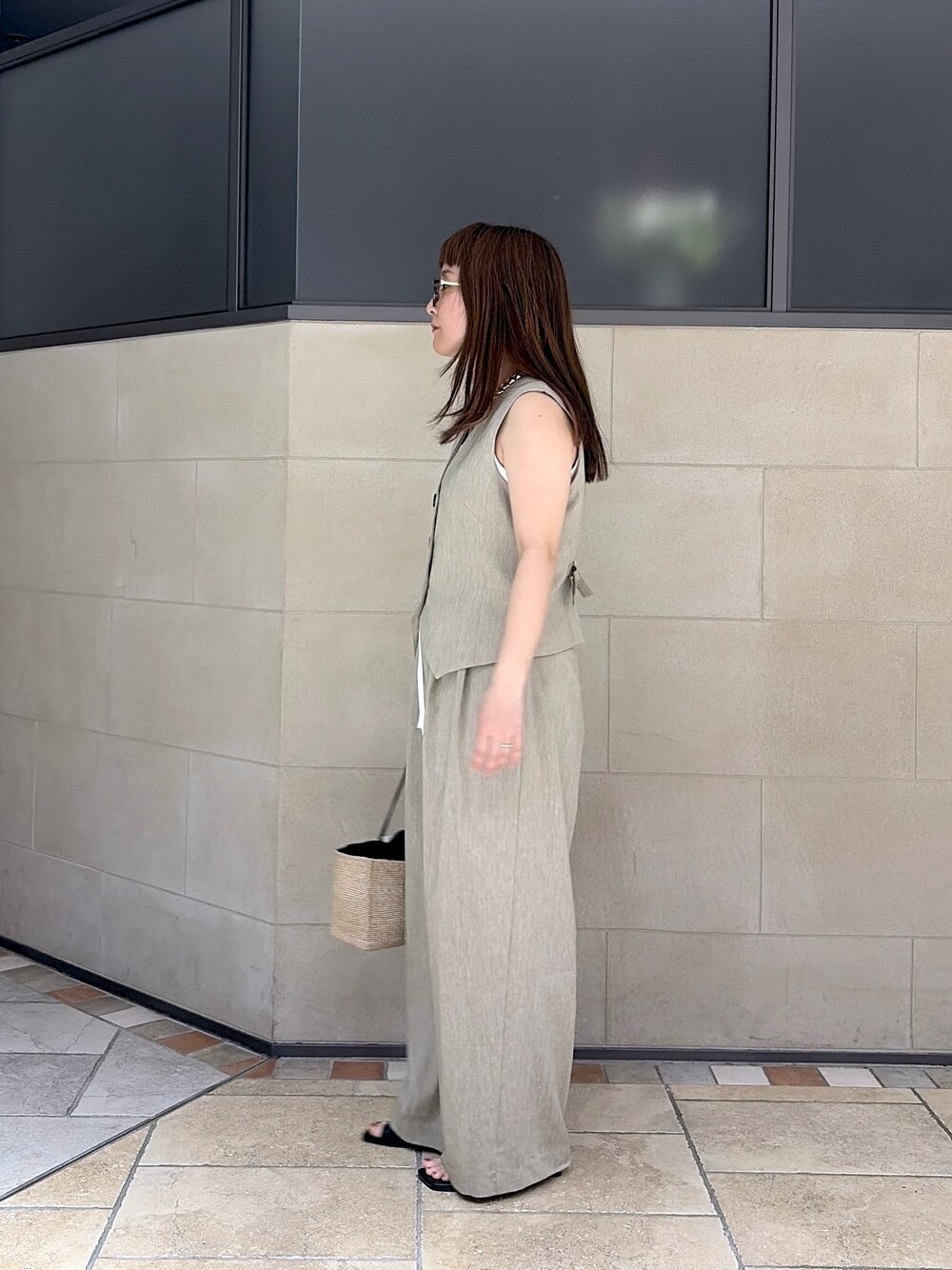 ベージュ系のベスト、ホワイト系のタンクトップ、ベージュ系のその他パンツを着用したレディースの春コーディネートの2枚目の写真