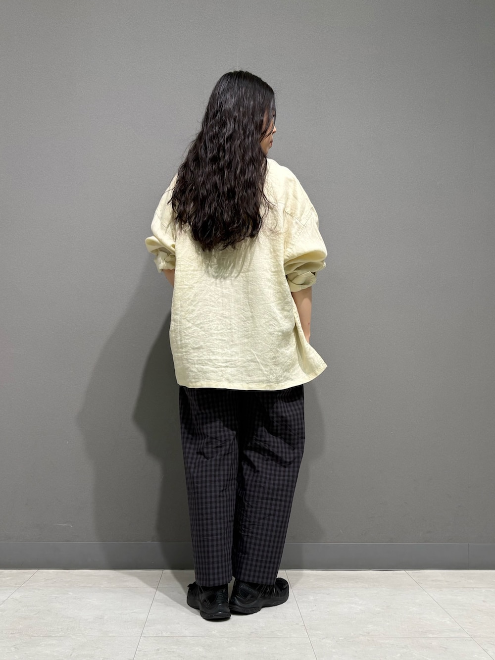 イエロー系のシャツ/ブラウス、グレー系のその他パンツ、ブラウン系のネックレスを着用したレディースの春コーディネートの4枚目の写真