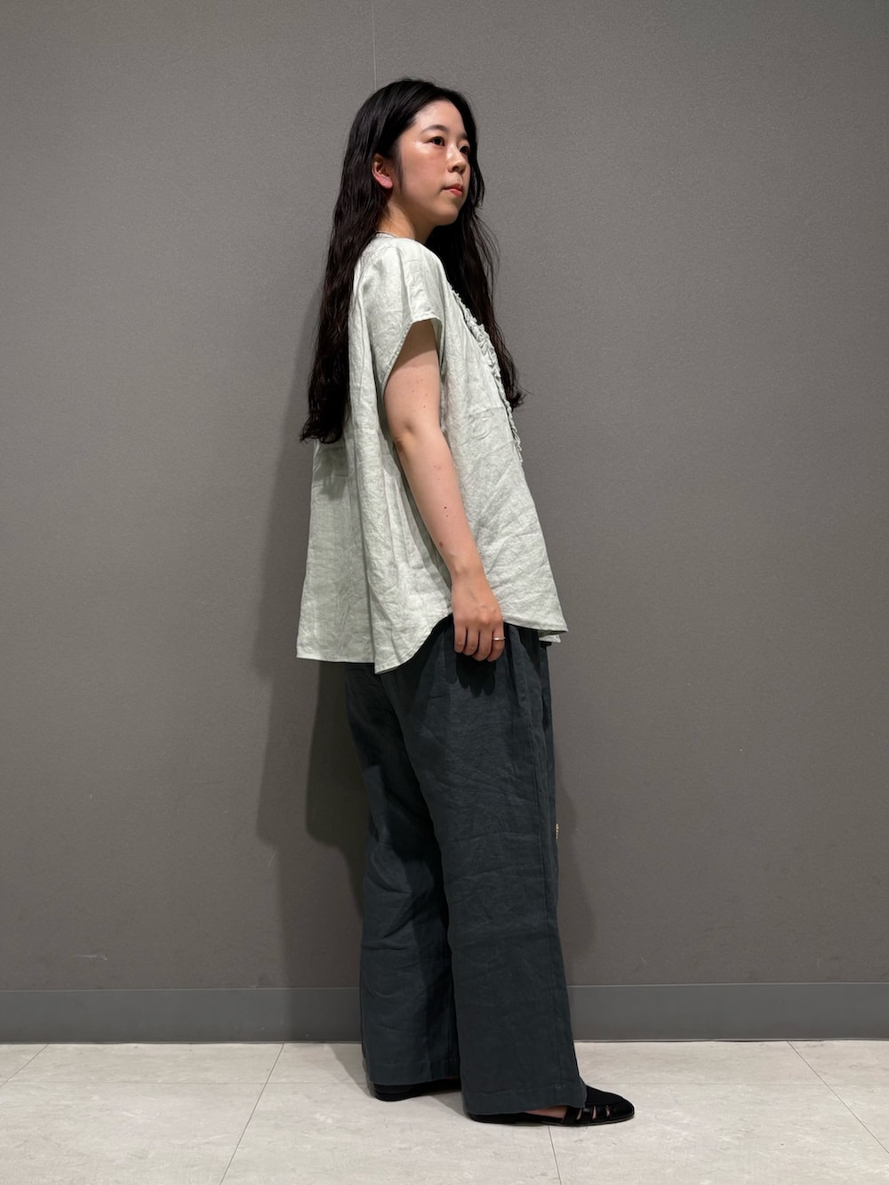 グリーン系のシャツ/ブラウス、ブルー系のその他パンツ、ブラック系のサンダルを着用したレディースの春コーディネートの4枚目の写真