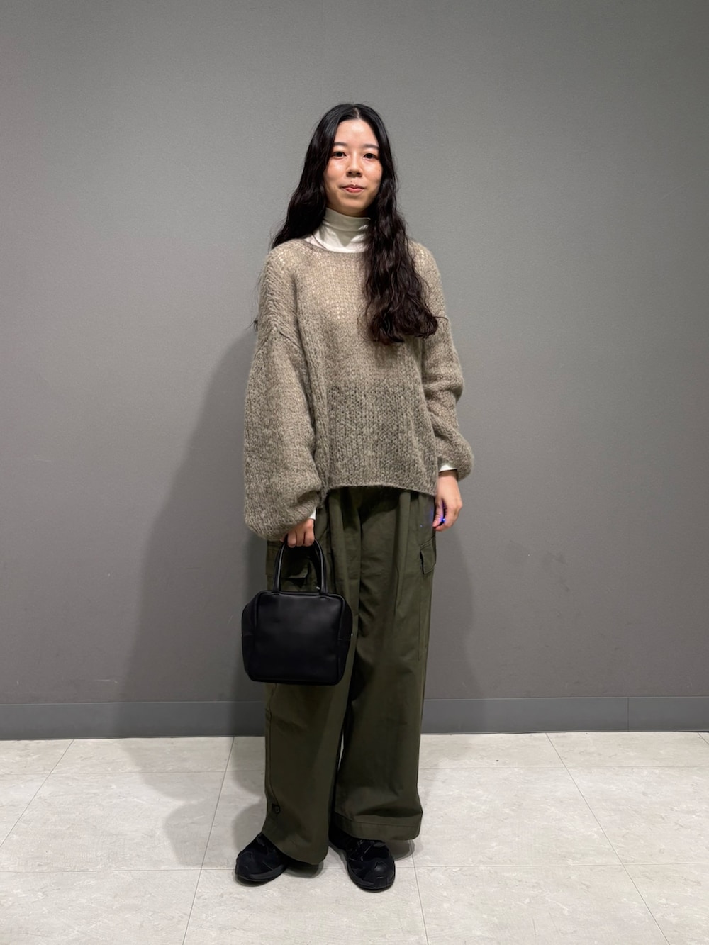 グレー系のニット/セーター、ホワイト系のTシャツ/カットソー、グリーン系のその他パンツを着用したレディースの秋コーディネートの2枚目の写真