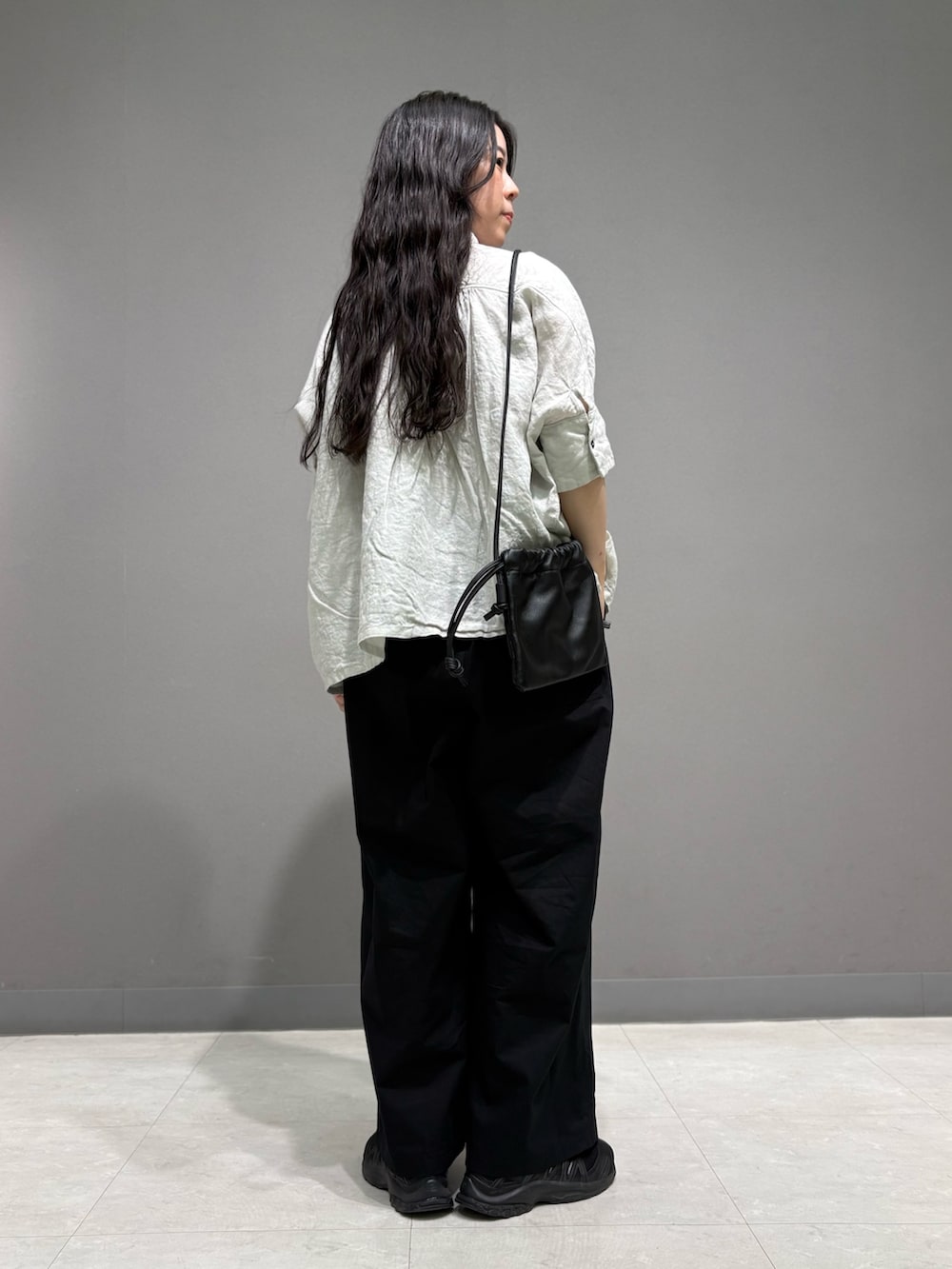 ブラック系のその他パンツ、ブラック系のショルダーバッグ、グレー系のシャツ/ブラウスを着用したレディースの春コーディネートの7枚目の写真
