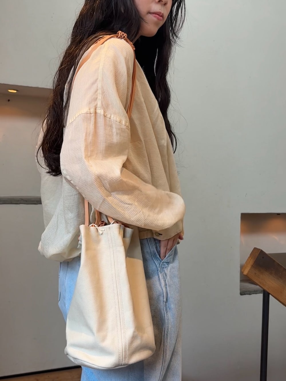 ベージュ系のシャツ/ブラウス、ブルー系のデニムパンツ、ホワイト系のその他雑貨を着用したレディースの夏コーディネートの6枚目の写真